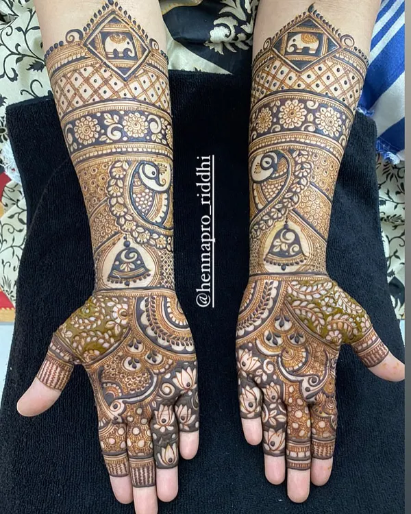 This elbow-length design is perfect for semi-bridal occasions. It features a mix of classic elements like peacocks, elephants, bells, and intricate jaal patterns for a full and festive look.