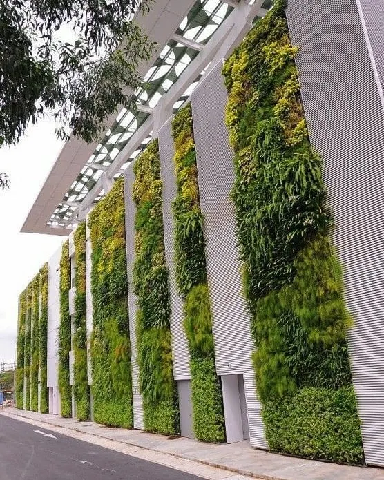 This is an example of a large-scale exterior installation on a modern office building. The vertical gardens are integrated into the facade design, creating a landmark green building.