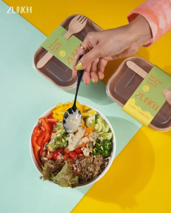 This is our Avocado Sunshine bowl, a vibrant mix of creamy avocado, quinoa, bell peppers, and a hint of jalapeño. Here you can see it getting a final drizzle of our signature dressing, ready to be packed and sent your way.