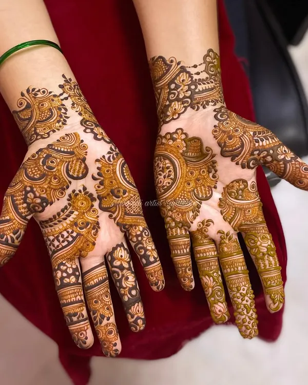 A beautiful Indo-Arabic design that flows diagonally across the hands, combining bold floral and paisley elements with finer, delicate patterns.