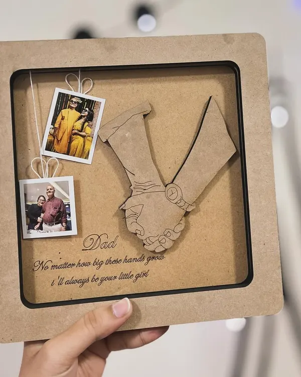 This custom frame was a special gift for a father. I replicated a photo of a father holding his daughter's hand in a wooden cutout, and added mini polaroids and a heartfelt message to complete the memory box.