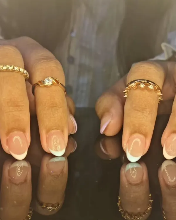 A classic and clean French manicure with crisp white tips on perfectly shaped oval nails, reflecting beautifully for a timeless look.
