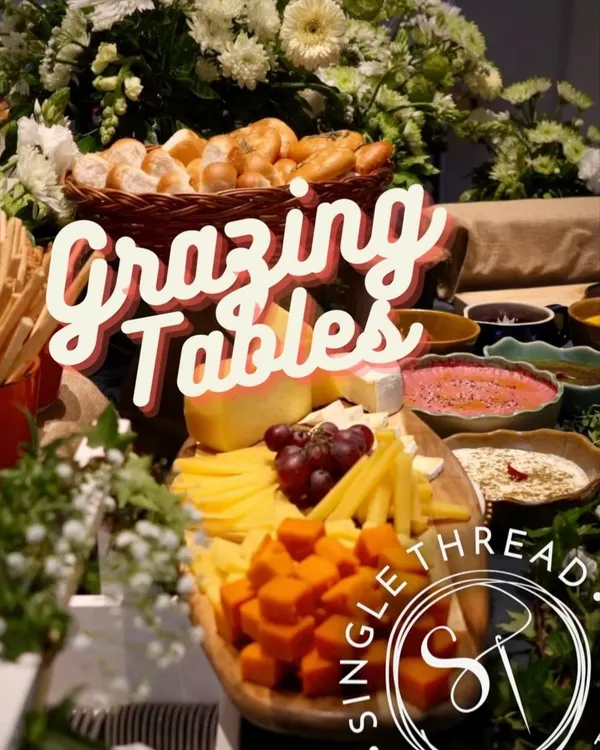 My grazing tables are designed to be inviting and layered. This one features a beautiful assortment of cheeses, fruits, and breads, set against a backdrop of fresh flowers.