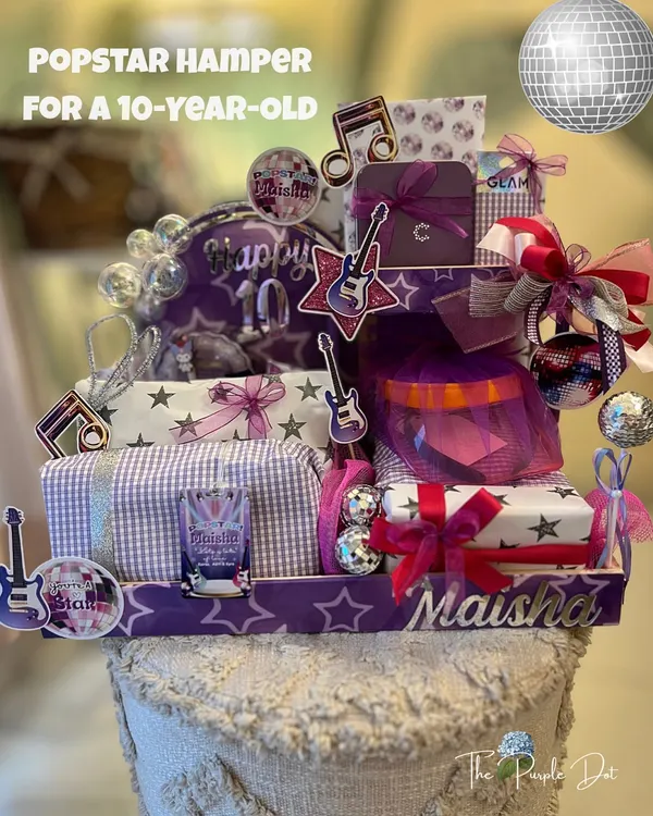 A popstar-themed hamper for a 10th birthday, designed to feel like a stage. I used a custom arch, disco balls, and personalized elements like the name 'Maisha' to create a gift with big energy for a big birthday.