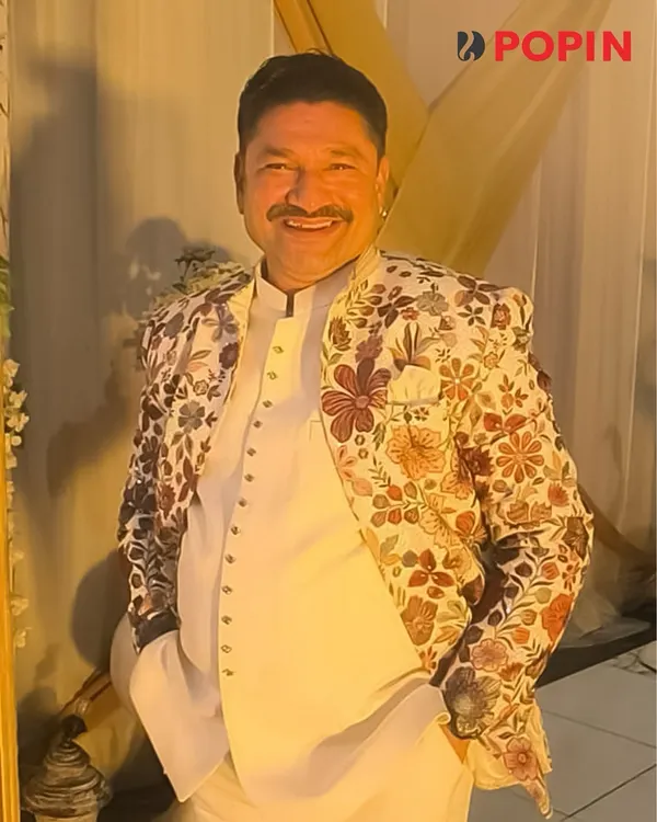 This client is wearing one of my unique floral embroidered jackets. It's a statement piece that pairs well with a simple white kurta, perfect for making a stylish impression at a wedding or festive gathering.