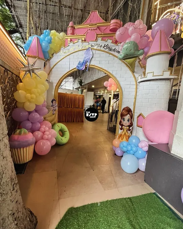 Welcome to the Disney Kingdom! This grand castle entrance arch, adorned with pastel balloons and candy props, sets a magical tone for a princess-themed birthday party.