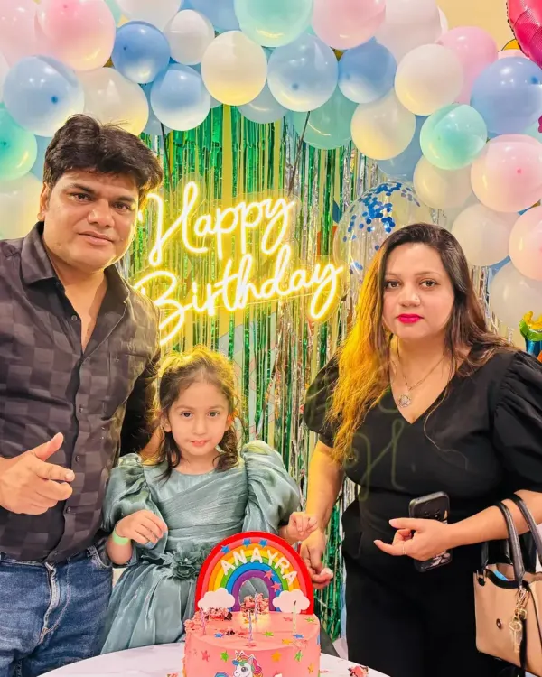 A happy family celebrating their daughter's 4th birthday with a unicorn cake. It's a joy to host these special family milestones.