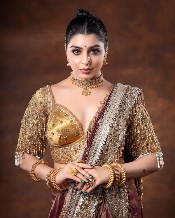 Is it my vibe or are you just blown away by my pallu? This shot captures the stunning detail of a heavily embroidered blouse and saree, a perfect look for a bride or wedding guest.