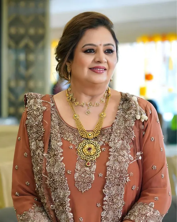 A radiant and joyful look for the mother of the groom during the Dhol party. The makeup is warm and glowing, paired with a sophisticated updo that complements her traditional jewelry and outfit.