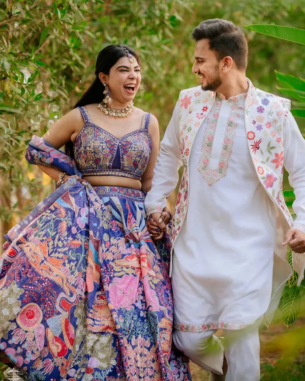 A moment of pure joy and laughter during a pre-wedding shoot. The couple's vibrant, coordinated outfits by Seema Gujral add a beautiful splash of color.