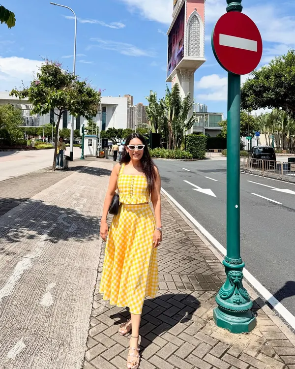 A full view of the custom yellow gingham check skirt and top co-ord set. This outfit is perfect for a sunny day out, a vacation, or a casual brunch, offering a cheerful and stylish look.