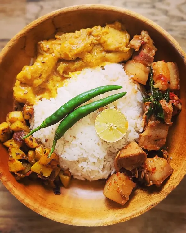 This is what a truly satisfying meal looks like to me. A complete homemade Naga thali featuring fluffy rice, my special Pork with Axone, creamy Kochu sabji, and crispy aloo fry, all served in a traditional wooden bowl.