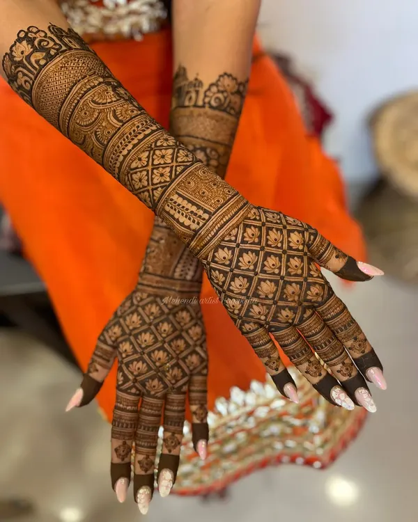 A classic grid or 'jaali' pattern is a timeless choice for the back of the hands. This design is filled with delicate lotus motifs, creating a look that is both intricate and elegant.