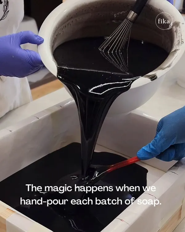 The process begins with the pour. Here, I'm hand-pouring a batch of rich, dark soap made with activated charcoal. This step is crucial for achieving a smooth, consistent texture in every single bar.