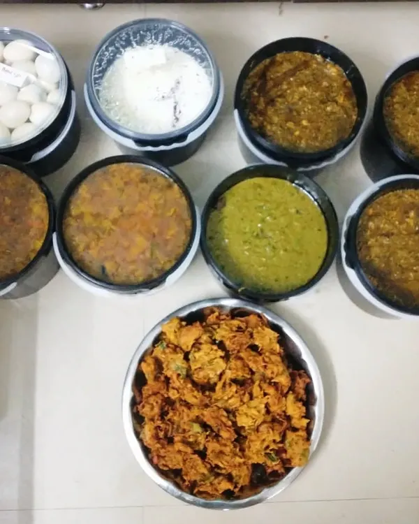 A large order prepared for a corporate company event for 80 people. You can see the different dishes like pakodi, curries, and boiled eggs packed and ready.