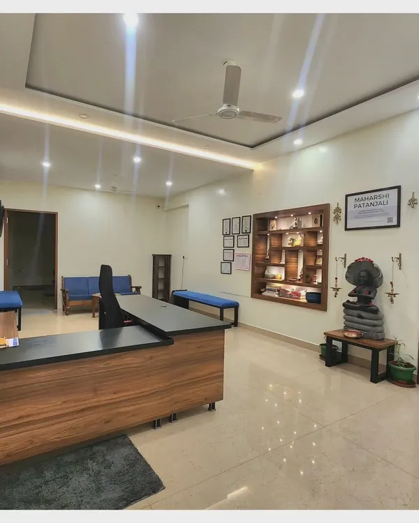 A view of our reception area, where your journey begins. The space is designed to be welcoming and calm, with a curated display of books and idols that reflect the philosophical heart of our practice.