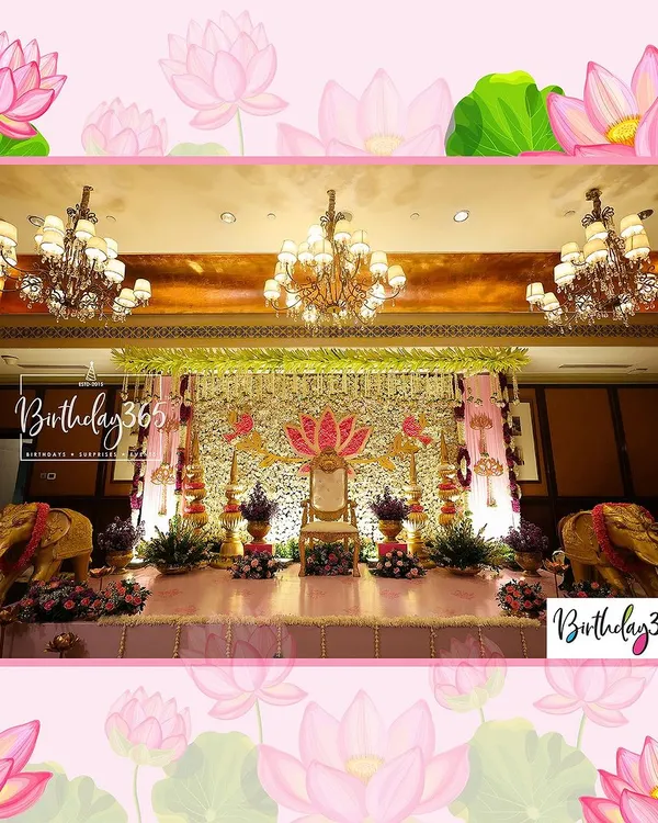 A breathtaking stage setup for a royal Half-Saree ceremony. The design features a magnificent floral wall, a grand throne for the guest of honour, and golden elephant statues, all unified by a traditional pink and gold lotus theme.