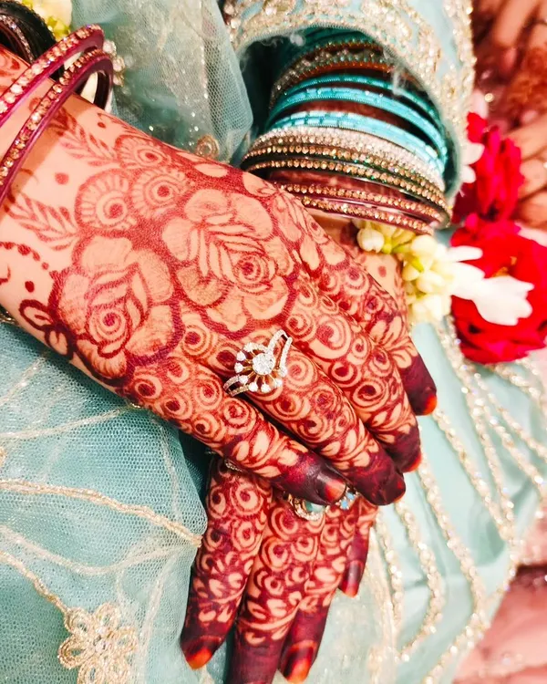 The beautiful, rich stain of an engagement henna, adorned with sparkling rings and bangles. This is the color of celebration.