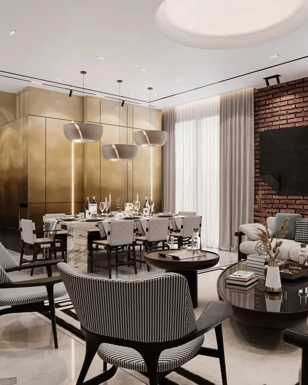 This open-plan living and dining area is defined by a striking brass-paneled wall that adds warmth and luxury. We used a mix of neutral tones, an exposed brick accent, and sleek, modern furniture to create a space that is perfect for both entertaining and relaxing.