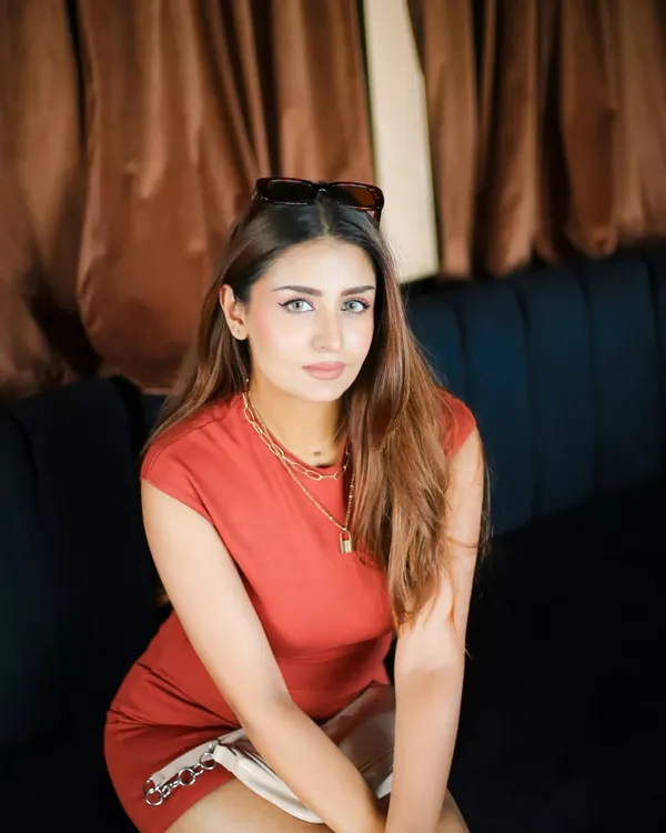 A relaxed and stylish portrait taken in a lounge. The warm, ambient lighting and comfortable seating create a chic lifestyle image, perfect for an influencer's feed.