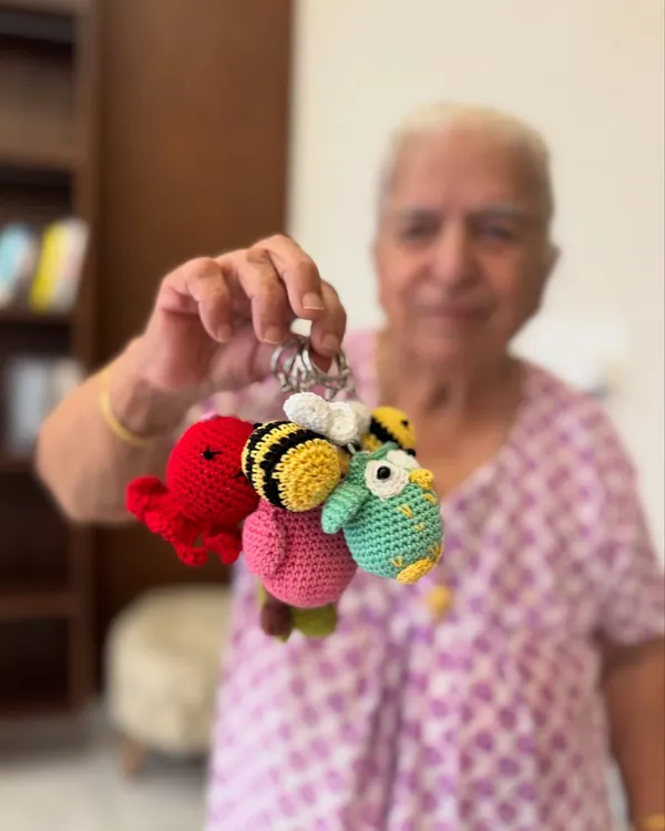 Dadi holding a handful of our cutest keychain charms. From bees to octopuses and owls, these little companions are sure to make you smile.