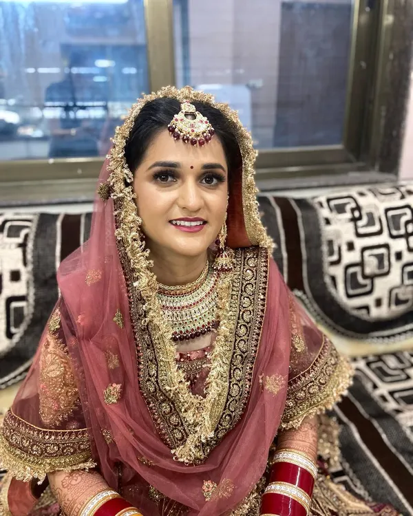A stunning Punjabi bride on her wedding day. I created a classic bridal look with soft smokey eyes and a rosy lip to complement her beautiful pink and gold lehenga.