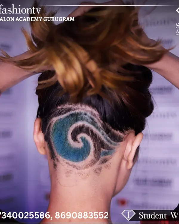 A close-up of a creative hair tattoo executed by a student. This style combines precision clipper work with vibrant color application, showcasing the advanced, artistic skills we teach.