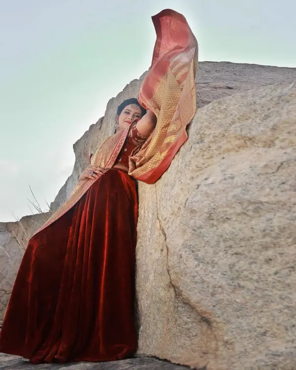 We used the wind to our advantage here, capturing the movement of the golden saree against the static, rugged texture of the rock. It creates a feeling of drama and elegance.