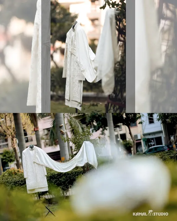 An artistic shot of the groom's white sherwani, hanging in a garden, a symbol of the day's beginning.