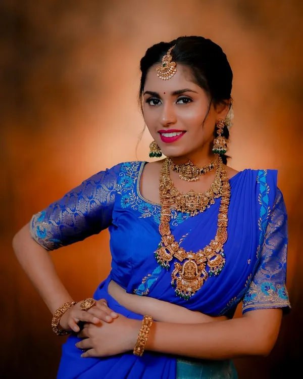 Here's a great example of mix-and-match styling. The same royal blue saree is styled with a heavy, traditional antique set for a grand look.