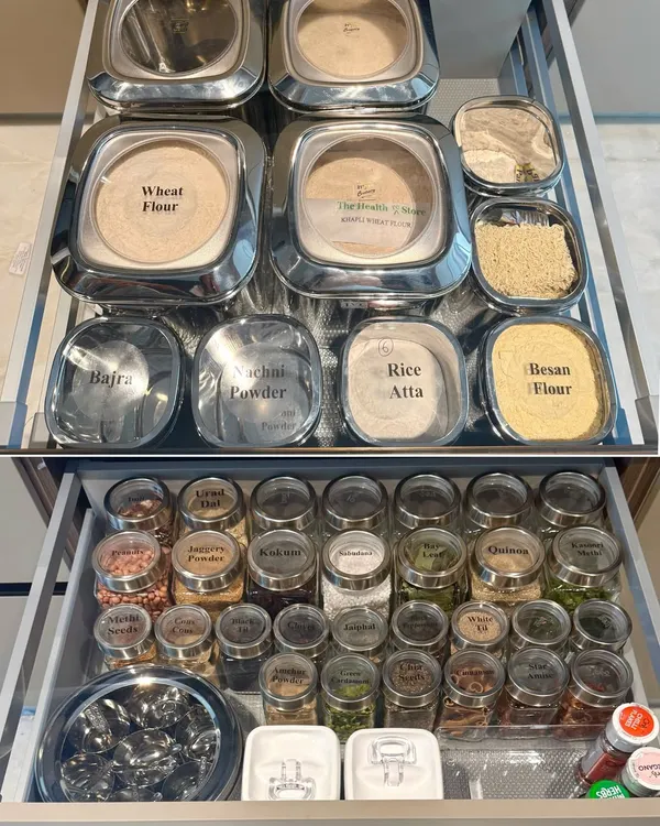 A complete pantry system in two drawers. We organized flours in large, accessible containers and spices in smaller, uniform jars, creating a visual and functional setup for Indian cooking essentials.