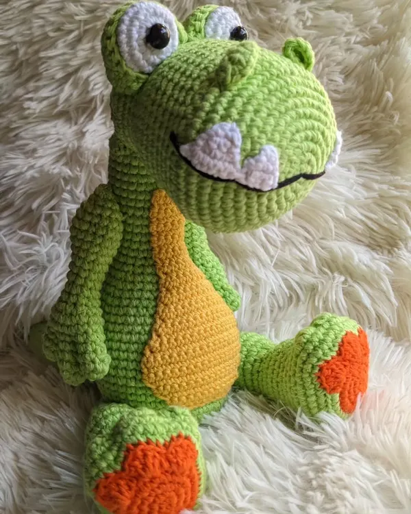 A big, friendly green dinosaur with a yellow belly and a wide grin. He's a soft and cuddly friend for any dino lover.