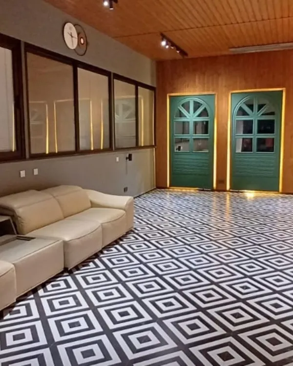 This floor makes a statement. The bold, black-and-white geometric pattern provides a high-contrast, modern foundation for this multi-purpose room, proving that the floor can be the main design feature.