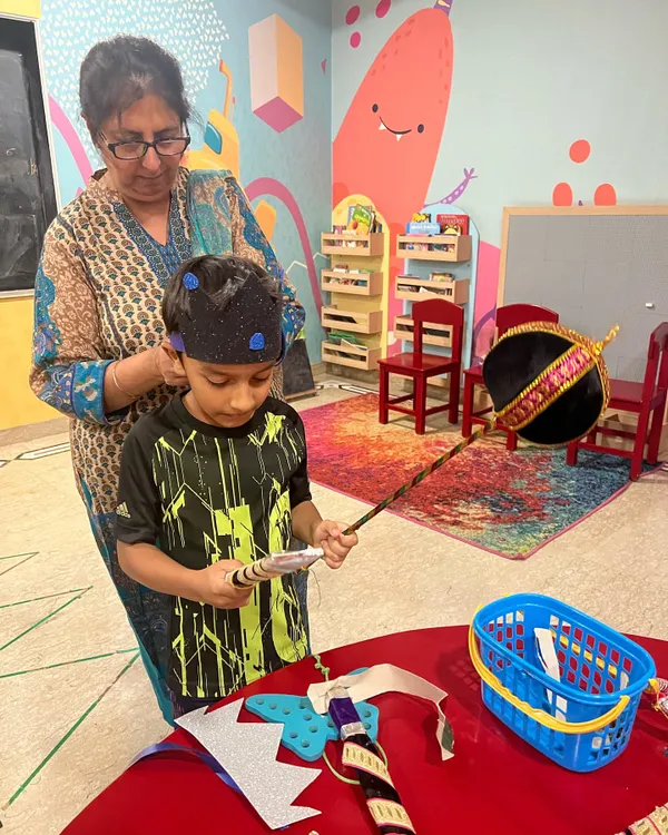 Our Ramleela preps are in full swing! Here I am helping one of our little actors with his crown. We make most of our props and costumes right here, which makes the whole experience more special for the kids.