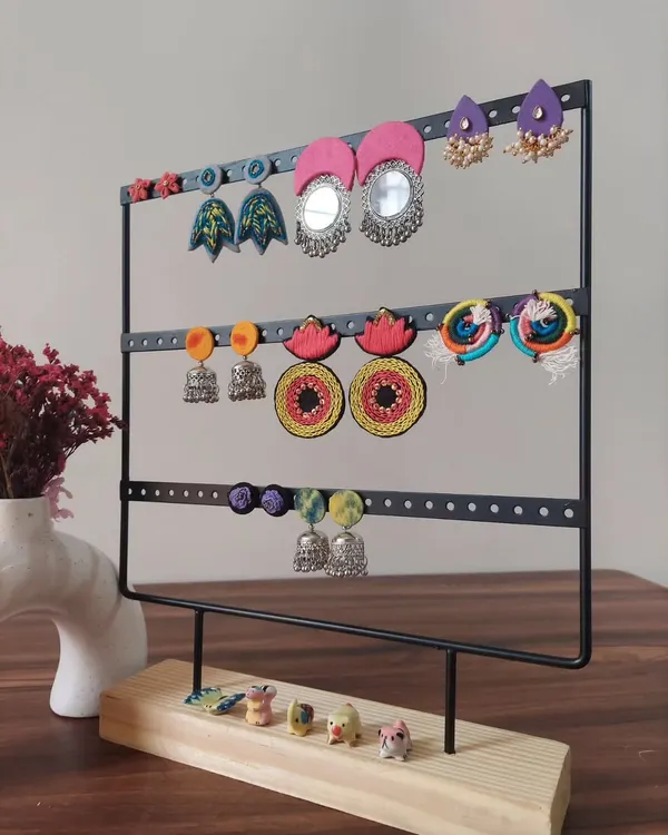 A display of the variety of earrings I create. You can see everything from large mirror work chandbalis and colorful jhumkis to hand-painted studs, all handmade by me.