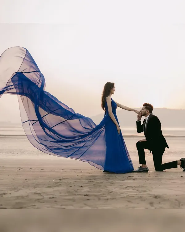 A true fairytale proposal on the beach. My royal blue trail gown creates a stunning visual as it catches the sea breeze, making for a truly memorable and romantic pre-wedding photo.