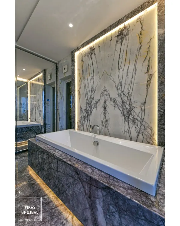 This bathroom is a masterpiece of marble. We used a dramatic, book-matched slab as an accent wall behind the bathtub, with backlighting to highlight its natural veining and create a stunning focal point.