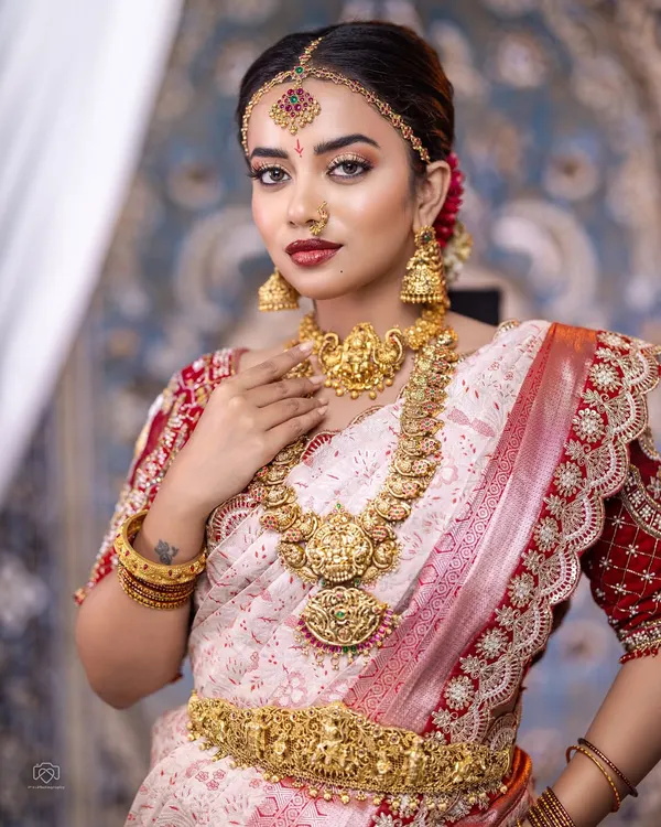 This is the ultimate South Indian bridal look. I love how this complete temple jewellery set, with its intricate Lakshmi motifs on the choker, long haram, and matha patti, creates a divine and timeless appearance for the big day.