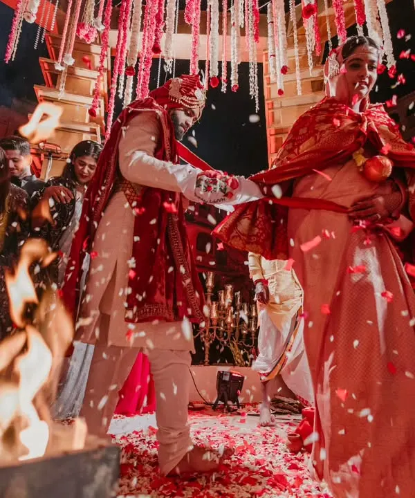 The sacred pheras around the holy fire. This shot, with the shower of red petals, feels like it's straight from a Sanjay Leela Bhansali film, full of tradition and grandeur.