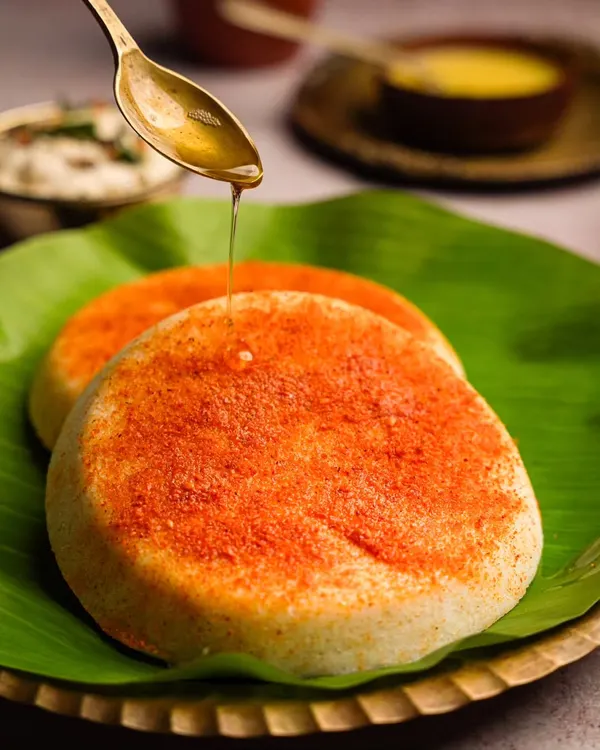 The perfect weekend breakfast for me is podi idli. This shot captures the soft, fluffy texture of the idlis, the vibrant color of the podi, and a glistening drizzle of ghee.