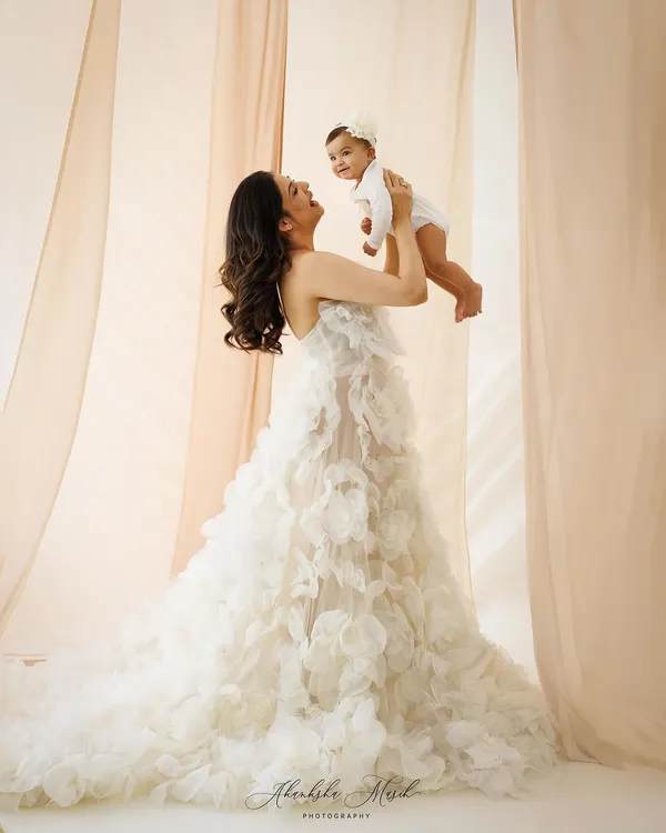 This portrait embodies the elegance and grace of motherhood. The flowing gown and soft lighting create a truly radiant and aspirational image, celebrating the powerful connection between a mother and her child.