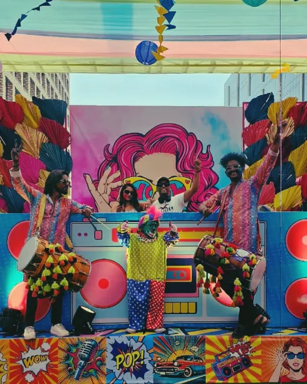 On stage at a massive Holi event, surrounded by dhol players and vibrant decor. There's nothing like the energy of a festival party, and I love being at the heart of the celebration.