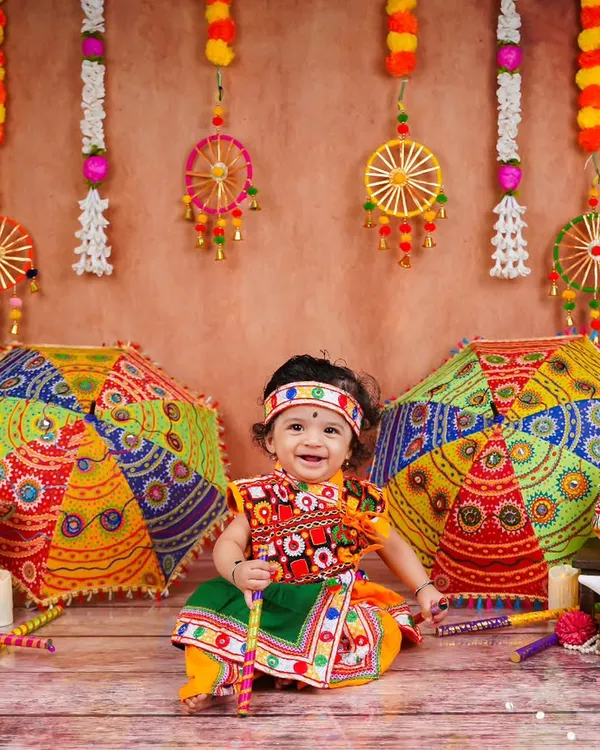 This is the kind of infectious smile I love to capture. Here, a little one is all dressed up for a Navratri themed shoot, surrounded by vibrant colors and festive props available right here in my studio.
