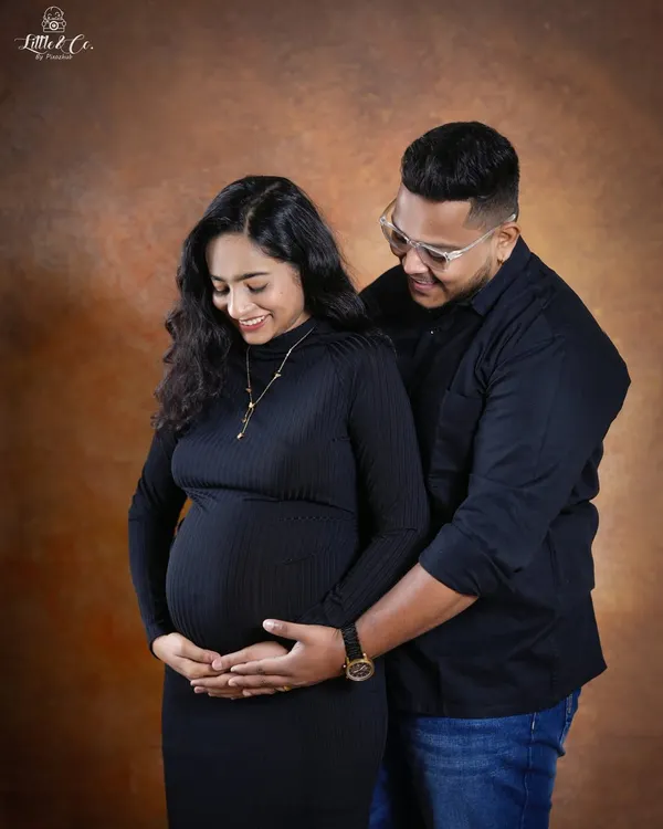 A tender moment between partners, both gently holding the baby bump. This pose emphasizes their shared journey and the love that surrounds their growing family.