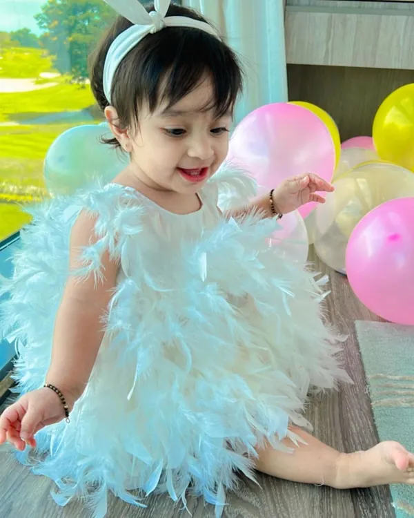 My daughter Aarriya celebrating her first birthday in a custom white feather dress. We designed this piece to be as magical as the moment, with soft, delicate feathers that create a dreamy, balloon-like silhouette perfect for a little one's big day.