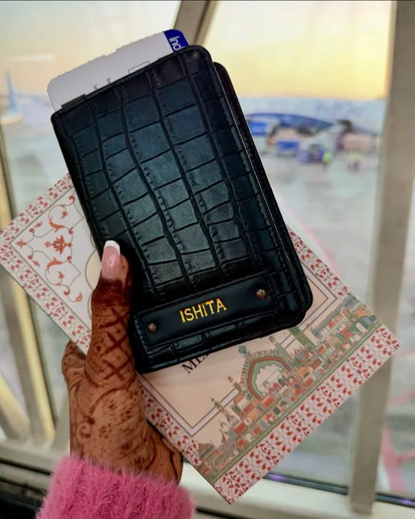 Your passport, your adventure. This stylish black passport cover is personalized with a name, making it the perfect accessory for your next journey.