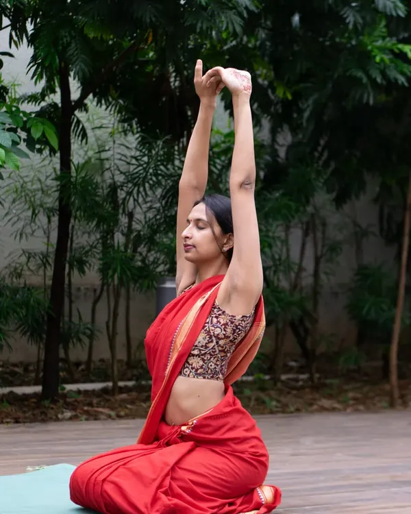 Yoga can be practiced anywhere, in any attire that feels comfortable. Here I am in a simple warm up stretch, showing that the essence of yoga is about finding stillness and breath, not perfection.