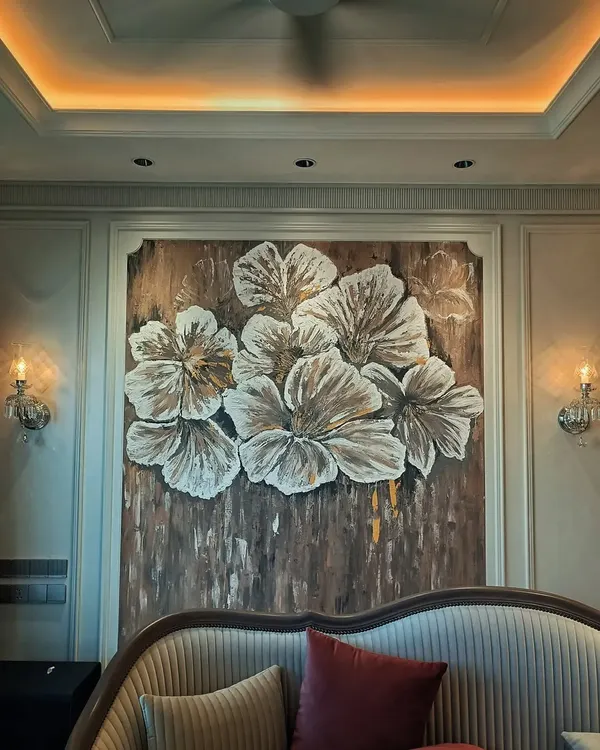 The final view of the textured floral mural, perfectly centered in an elegant bedroom. The warm lighting highlights the raised texture of the petals, creating a stunning focal point.