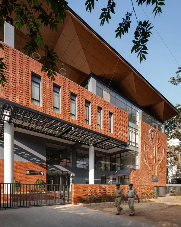 The exterior of the Nirbhaya Centre in Bangalore, featuring a distinctive brick mural and a welcoming entrance shaded by a 100-year-old raintree.