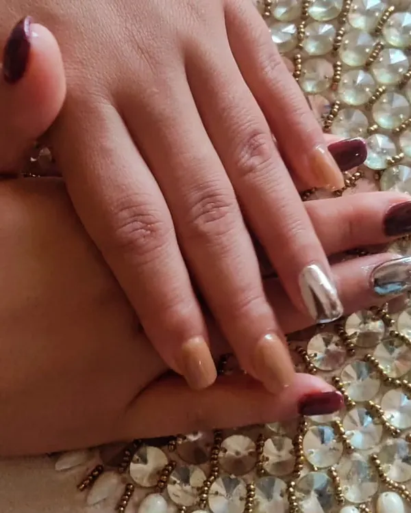 A sophisticated set combining solid maroon, nude, and striking silver chrome accent nails on short, square extensions.